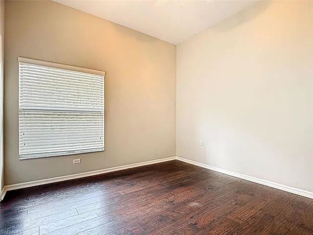 Spare room featuring dark wood-style floors and ceiling fan