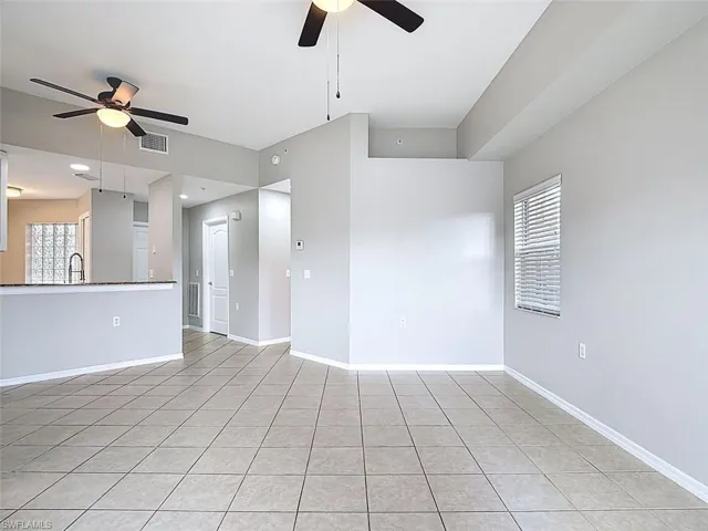 Unfurnished living room with ceiling fan and light tile patterned flooring