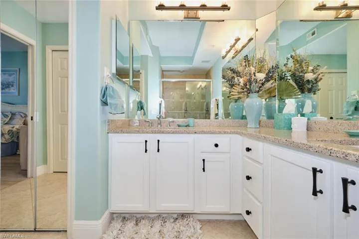 Bathroom featuring tile patterned floors, vanity, and a shower with shower door