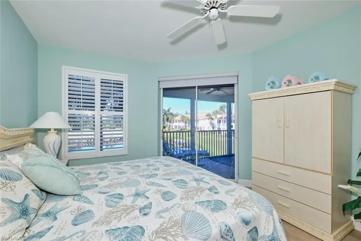 Bedroom with hardwood / wood-style floors, access to outside, and ceiling fan