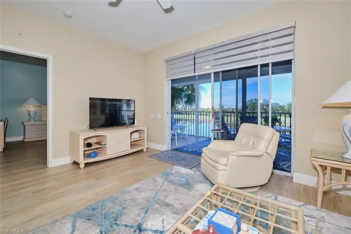 Living room with ceiling fan and hardwood / wood-style floors