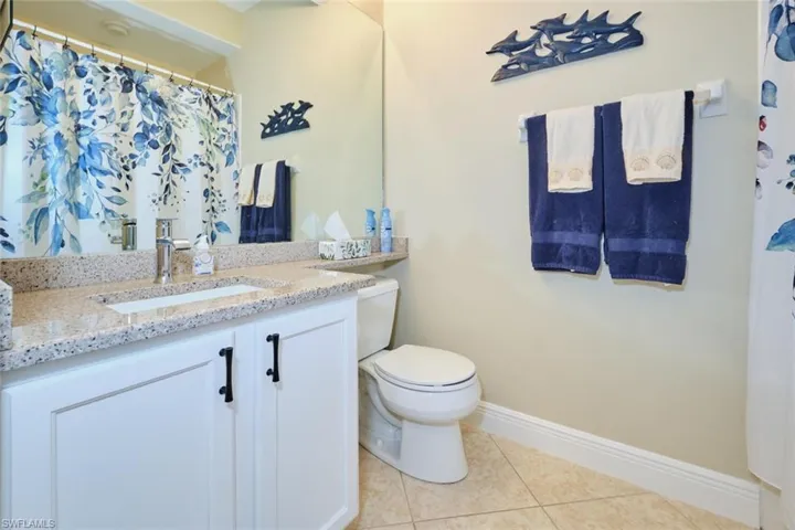 Bathroom with toilet, vanity, and tile patterned floors