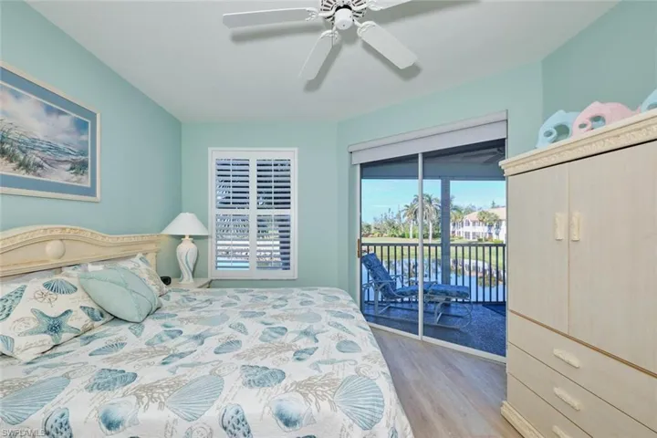 Bedroom with hardwood / wood-style floors, access to outside, and ceiling fan