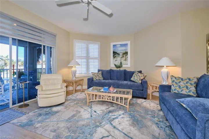 Living room with ceiling fan and hardwood / wood-style floors