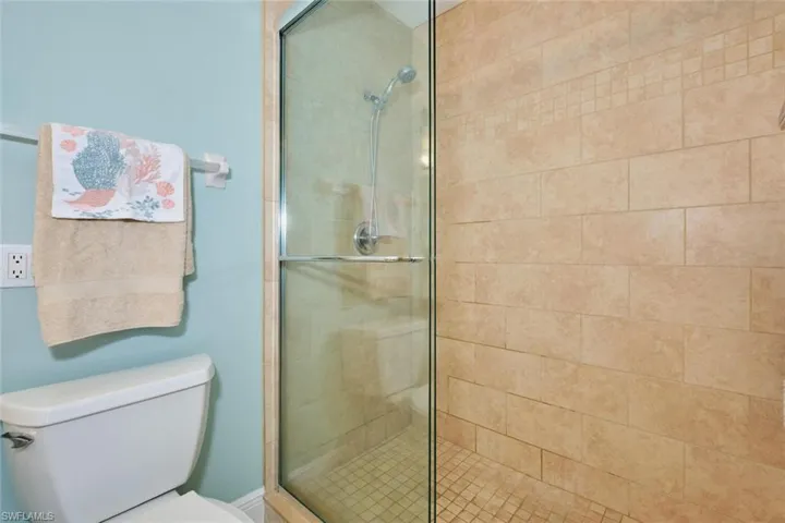 Bathroom featuring toilet and a shower with door