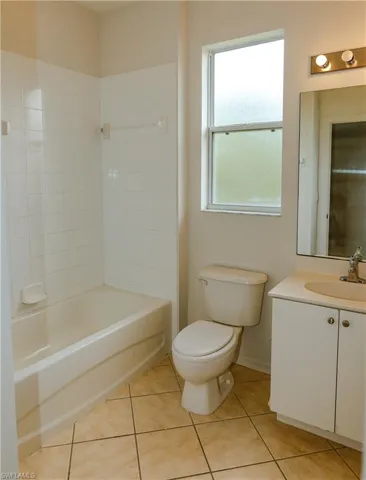 Bathroom featuring vanity, light tile patterned flooring, and bathtub / shower combination
