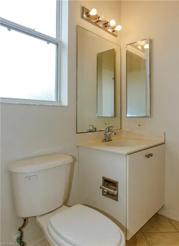 Half bath featuring light tile patterned floors and vanity