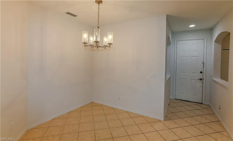 Unfurnished dining area with light tile patterned flooring, a chandelier, and recessed lighting