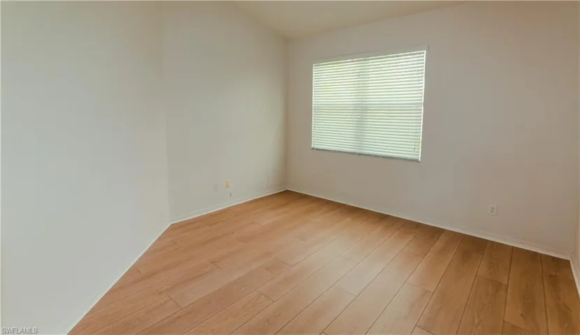 Unfurnished room with baseboards and light wood-type flooring