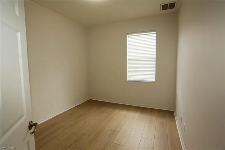 Unfurnished room with light wood-type flooring and baseboards