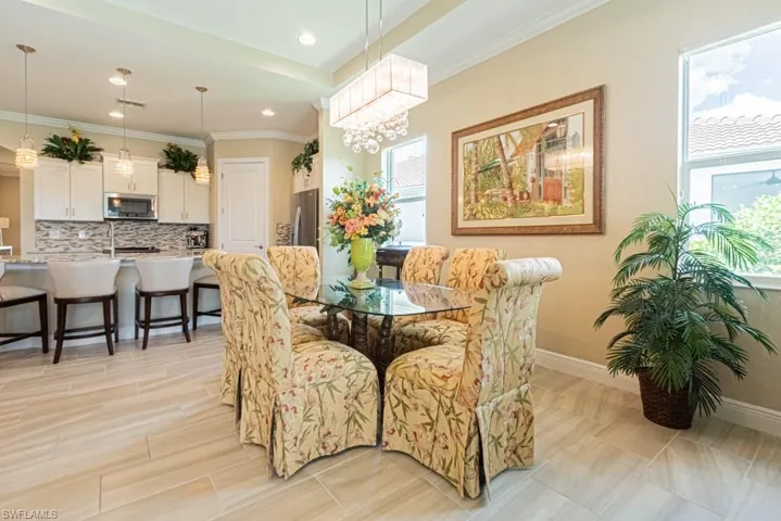 Tiled dining area featuring crown molding and a notable chandelier