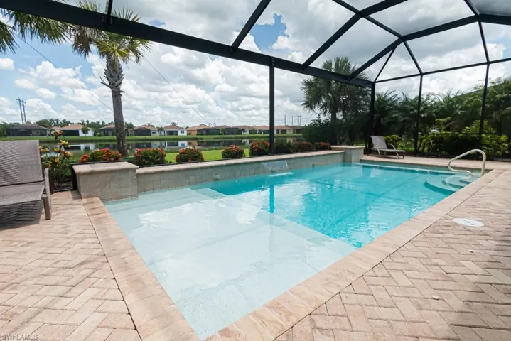 View of pool featuring a lanai, pool water feature, and a patio