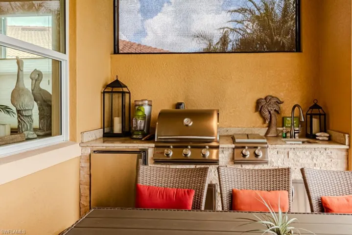 View of patio with sink, a grill, and exterior kitchen