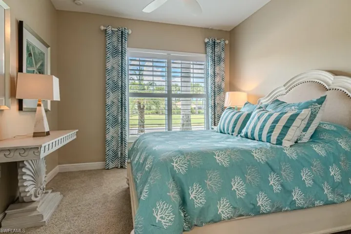 Carpeted bedroom featuring ceiling fan