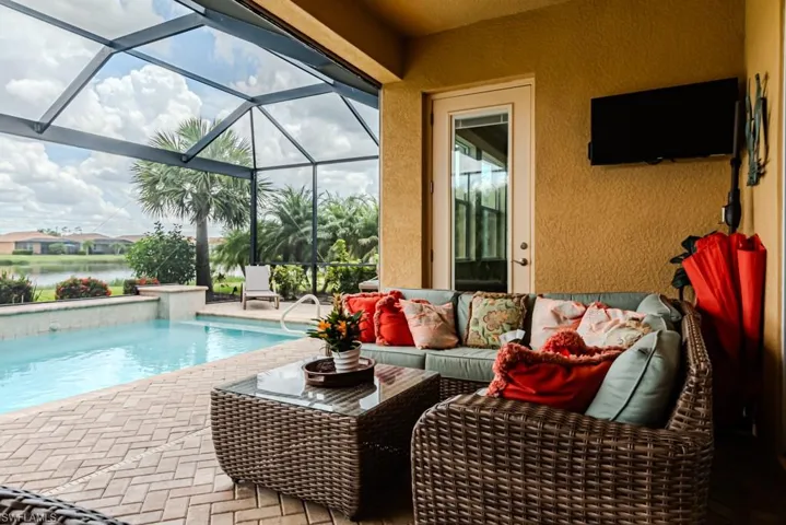View of swimming pool featuring glass enclosure and a patio area