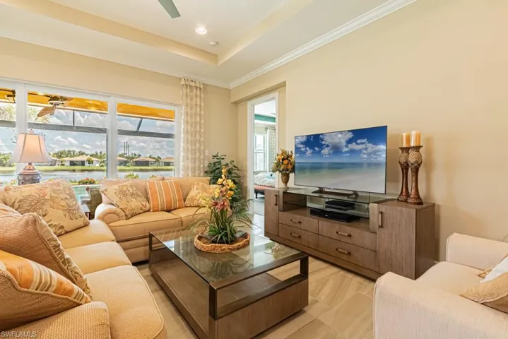 Living room featuring a raised ceiling and ornamental molding