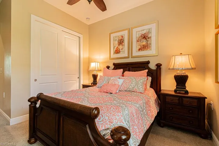 Bedroom featuring a closet, light colored carpet, and ceiling fan