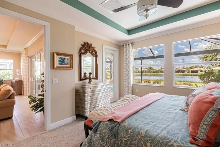 Bedroom featuring ceiling fan, crown molding, and a tray ceiling