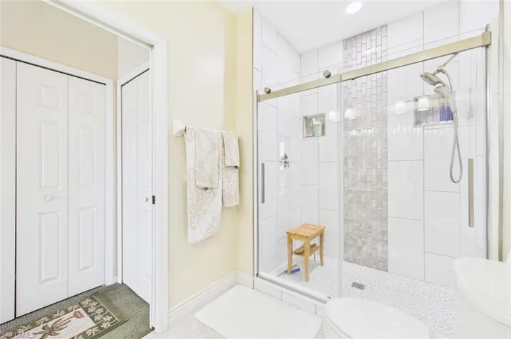 Full bath with a closet, a stall shower, and tile patterned flooring
