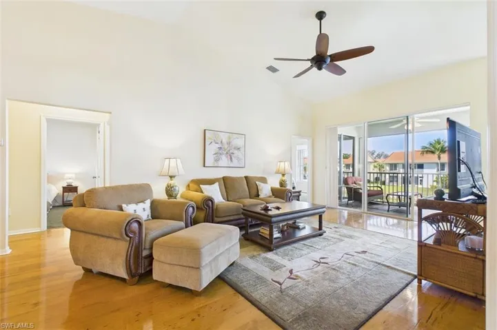 Living room featuring light wood-style floors, ceiling fan, and high vaulted ceiling