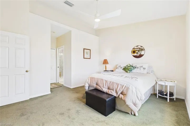 Bedroom featuring carpet floors, ceiling fan, and ensuite bathroom