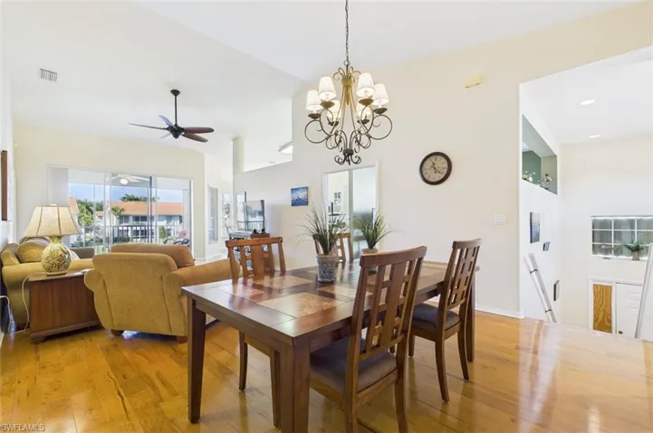 Dining space with light wood-type flooring, a chandelier, and a ceiling fan