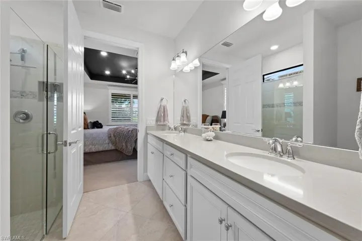 Bathroom with vanity, tile patterned floors, and a shower with shower door