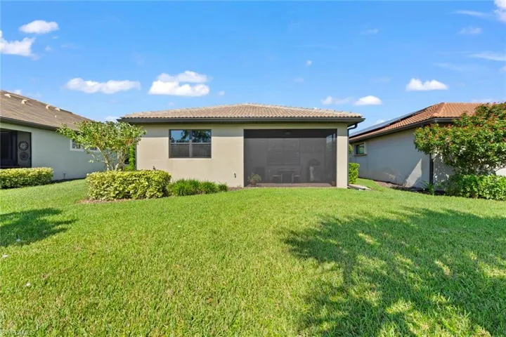 Back of property featuring a lawn and a sunroom