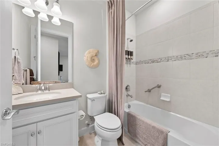 Full bathroom featuring shower / bathtub combination with curtain, vanity, and toilet