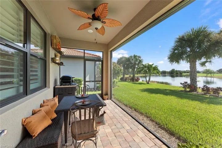 Sunroom / solarium featuring ceiling fan and a water view