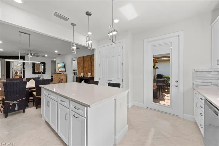 Kitchen with pendant lighting, dishwasher, tasteful backsplash, white cabinetry, and ceiling fan