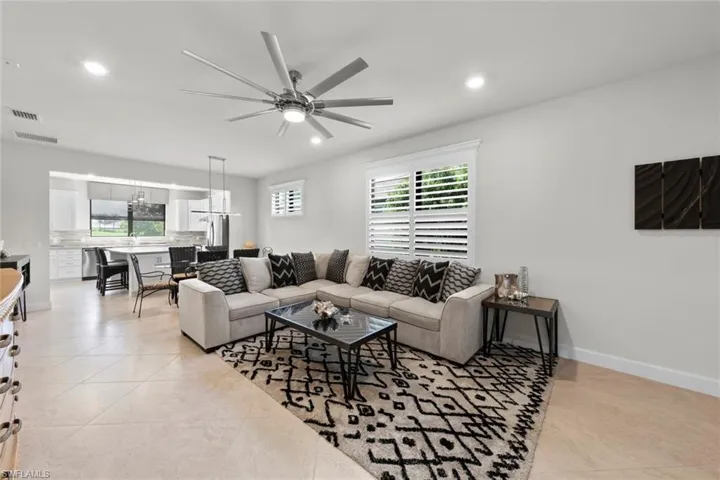 Living room featuring light tile patterned floors and ceiling fan