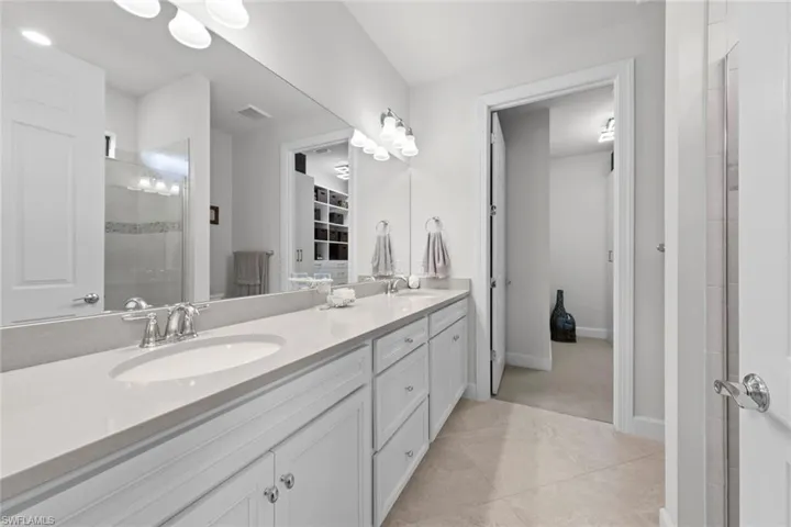 Bathroom with tile patterned floors, walk in shower, and vanity