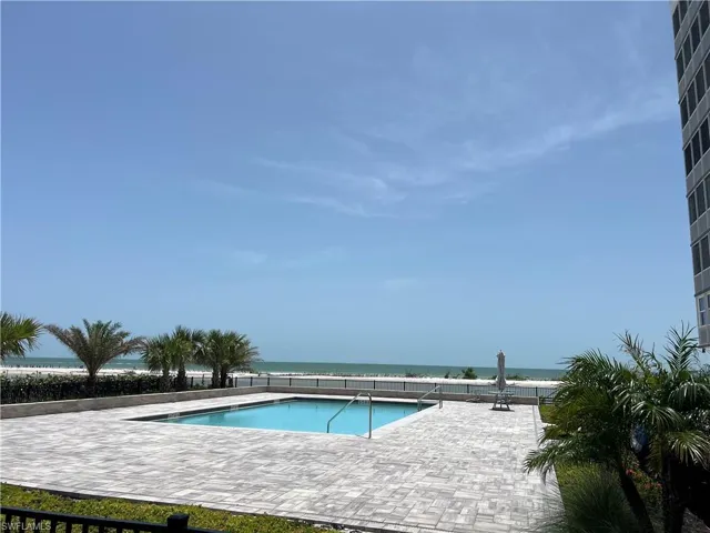 new Community pool featuring a water view and a patio