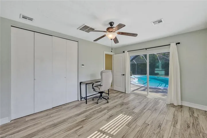 Home office with light wood-style flooring, visible vents, a ceiling fan, and baseboards