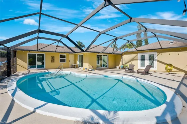Pool with french doors, glass enclosure, and a patio