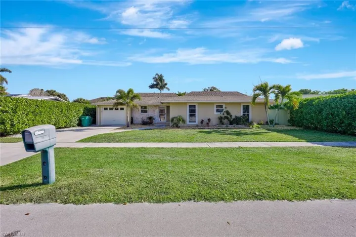 Ranch-style house with stucco siding, an attached garage, a front yard, and concrete driveway