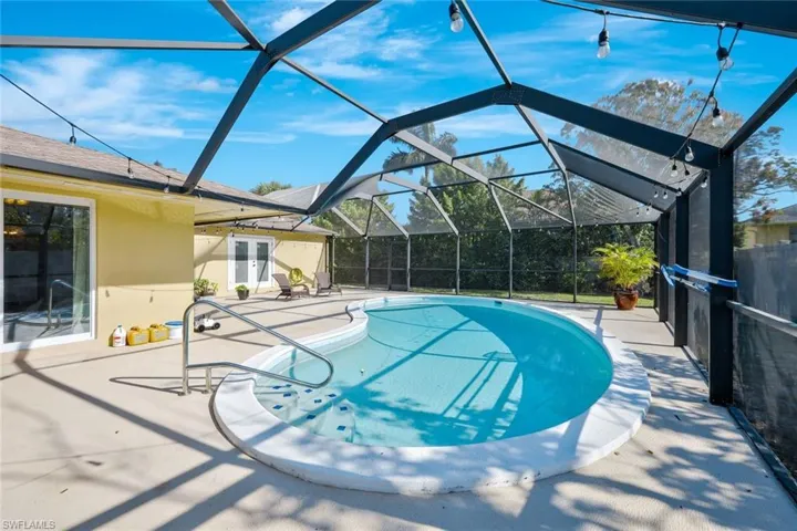 Pool with a lanai, a patio area, and french doors