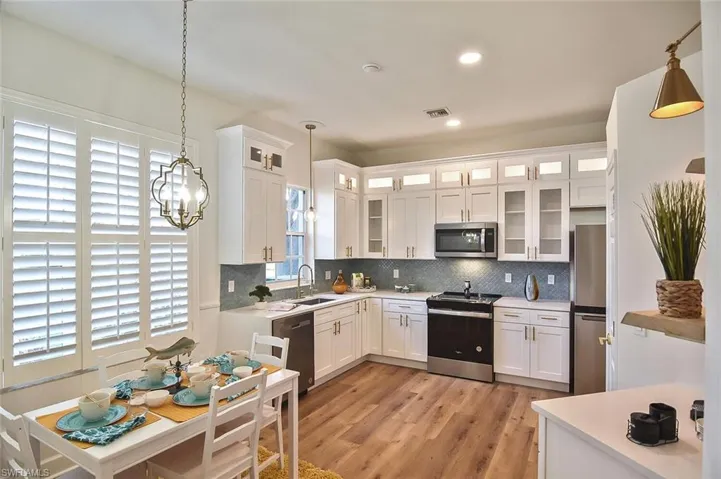 Kitchen with plenty of natural light, sink, stainless steel appliances, and light hardwood / wood-style floors