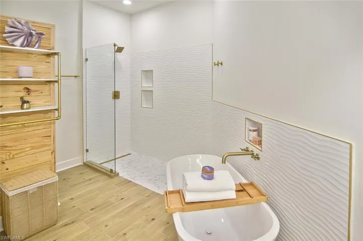 Bathroom with hardwood / wood-style flooring and separate shower and tub