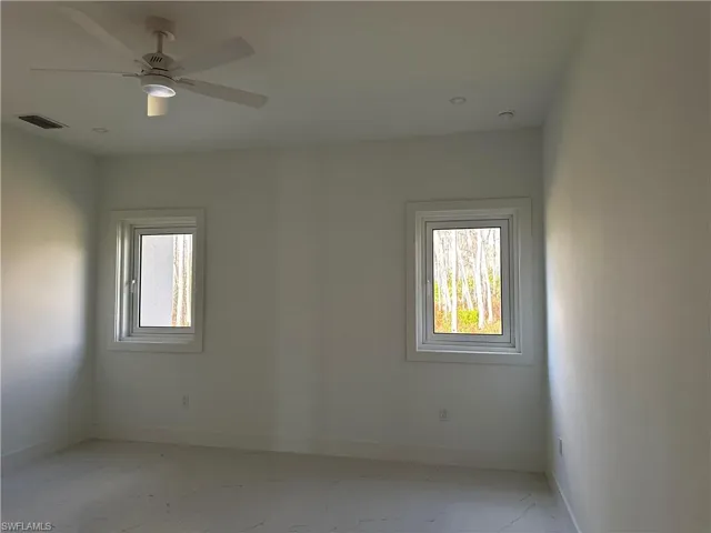 Spare room featuring plenty of natural light and ceiling fan