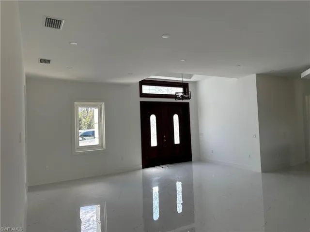 Entryway featuring light marble finish floors and recessed lighting