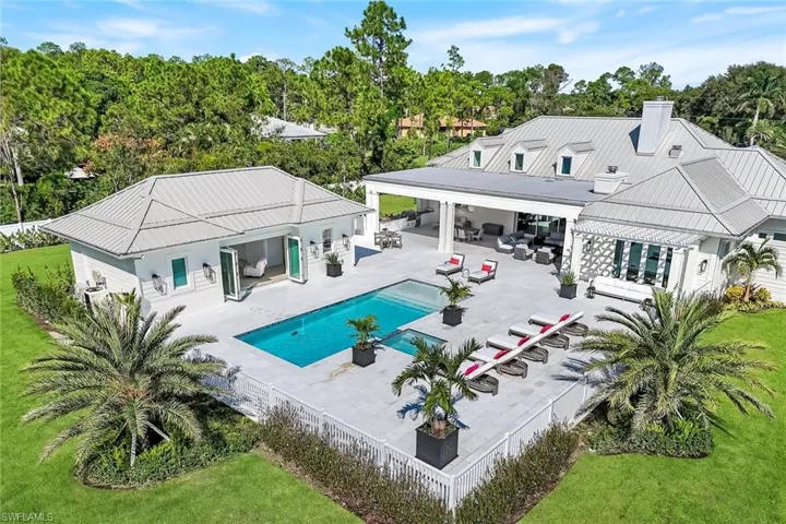 Back of property with a patio area, a fenced backyard, view of scattered trees, and a chimney