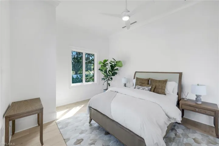 Bedroom featuring wood finished floors, crown molding, ceiling fan, and lofted ceiling