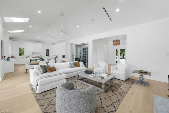 Living area with light wood-style flooring, recessed lighting, and a skylight