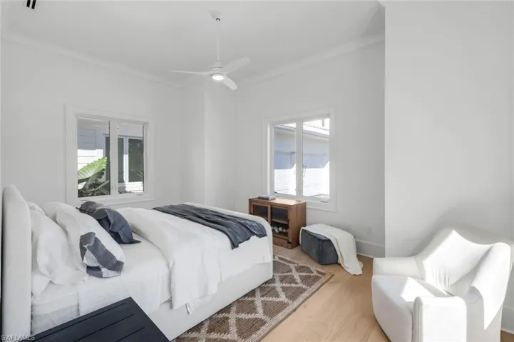 Bedroom featuring crown molding, wood finished floors, and a ceiling fan