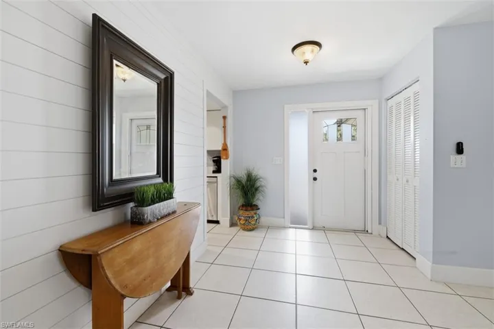 Entrance foyer with wood walls and light tile patterned floors