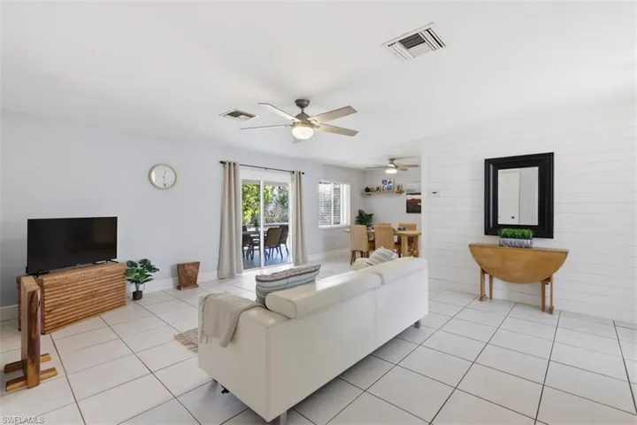 Living room featuring light tile patterned floors and a ceiling fan