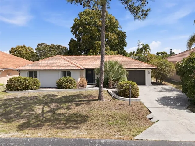 View of front of property with stucco siding, a tiled roof, an attached garage, and concrete driveway