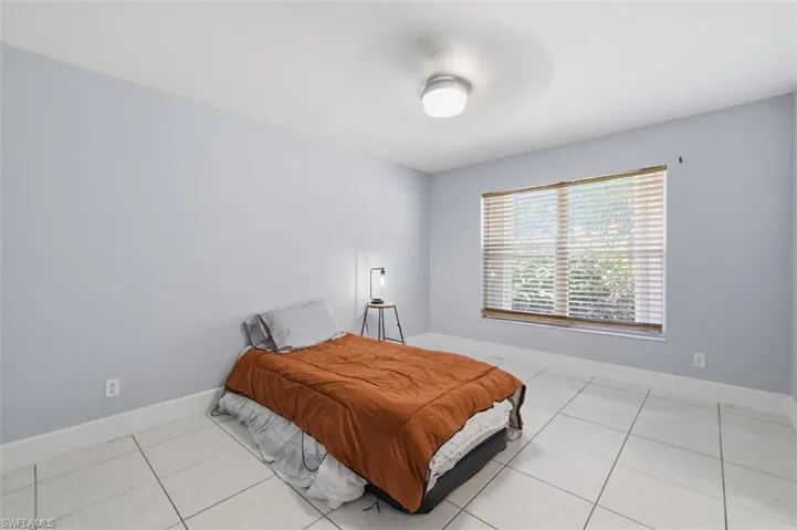 Bedroom featuring light tile patterned floors and a ceiling fan